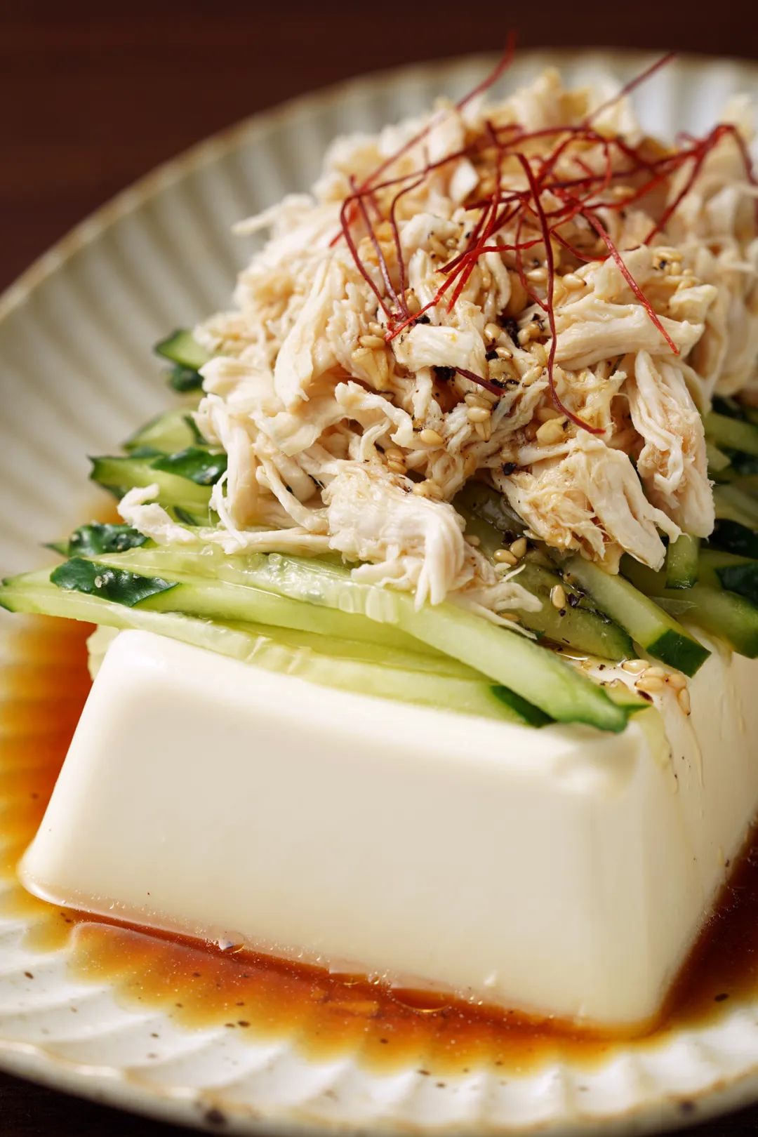 Layering tofu, chicken, and cucumbers